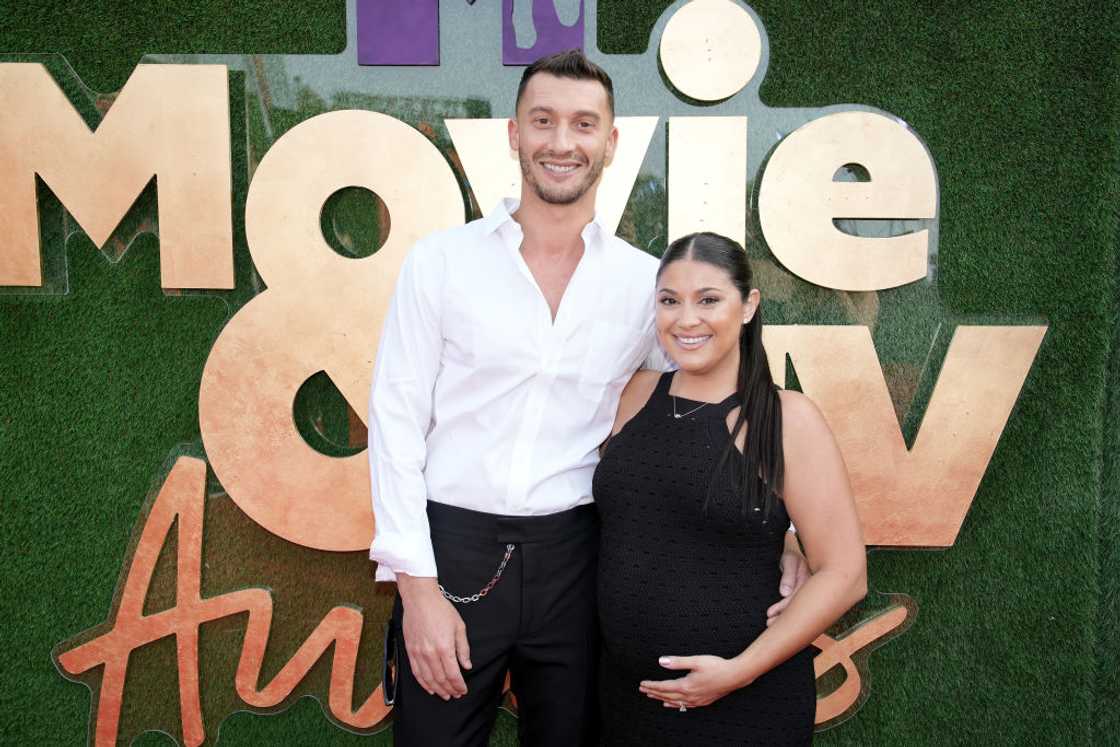 Alexei in a white shirt stands beside Loren in a black dress in front of an MTV Movie & TV Awards backdrop.