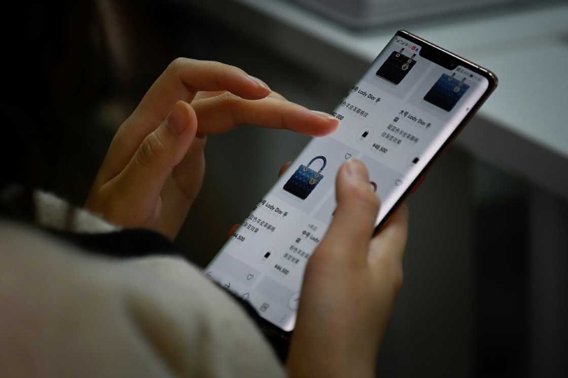 A student looks at her phone during a lesson at the Extraordinary Luxuries Business School in Beijing A student looks at her phone during a lesson at the Extraordinary Luxuries Business School in Beijing