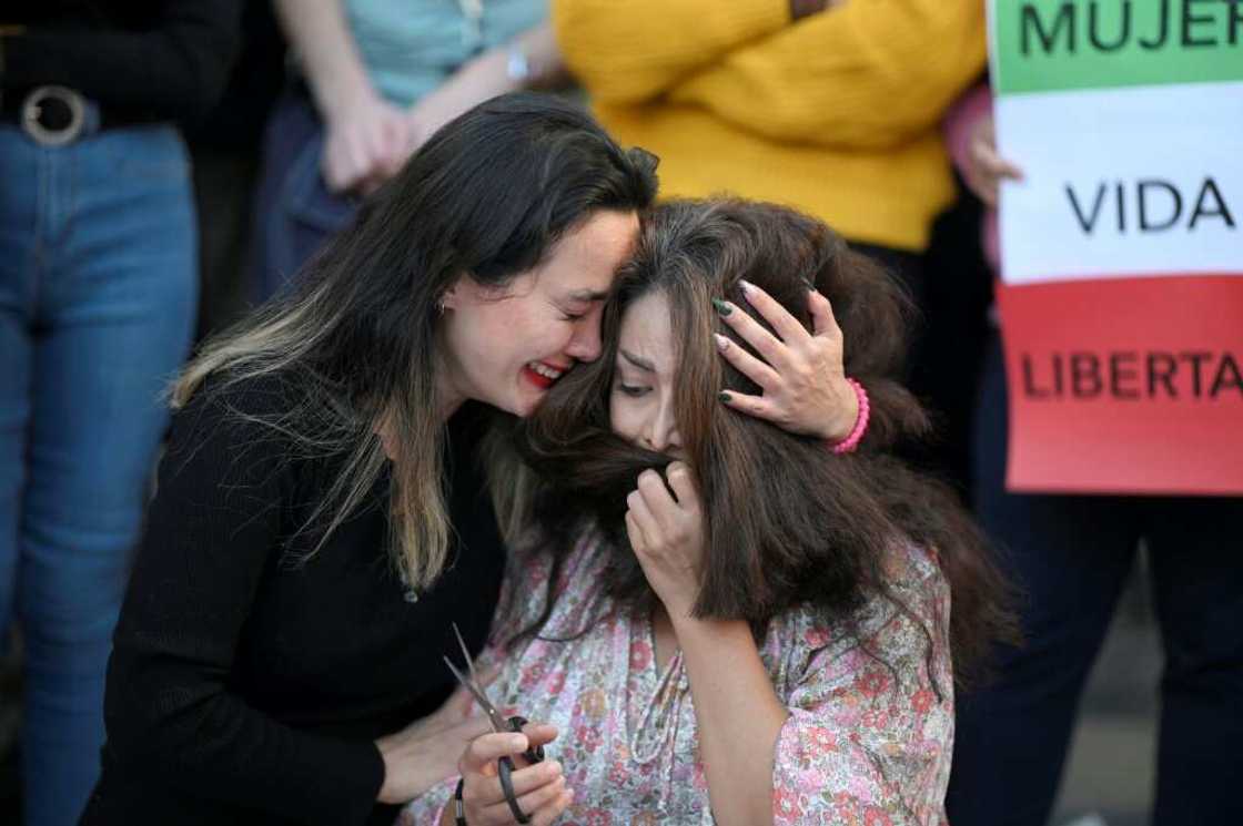 A protester cries as another cuts her hair during a demonstration in support of Kurdish woman Mahsa Amini on Saturday in Madrid A protester cries as another cuts her hair during a demonstration in support of Kurdish woman Mahsa Amini on Saturday in Madrid