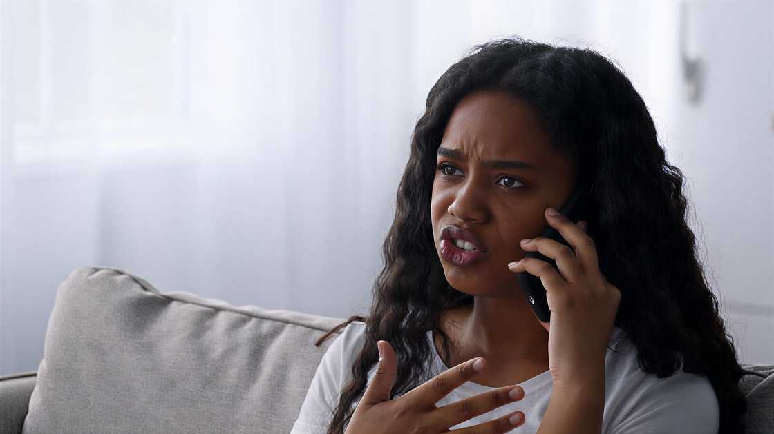 Close-up shot of a black teen girl emotionally talking on a cellphone