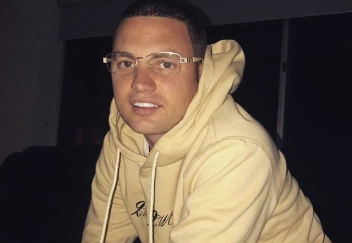 Kerser posing for a photo in a cream hoodie Kerser posing for a photo in a cream hoodie