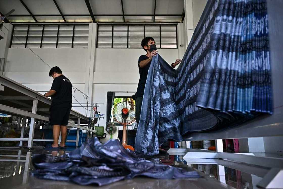 Workers in Chiang Mai prepare to cut elephant print fabric into clothing patterns Workers in Chiang Mai prepare to cut elephant print fabric into clothing patterns