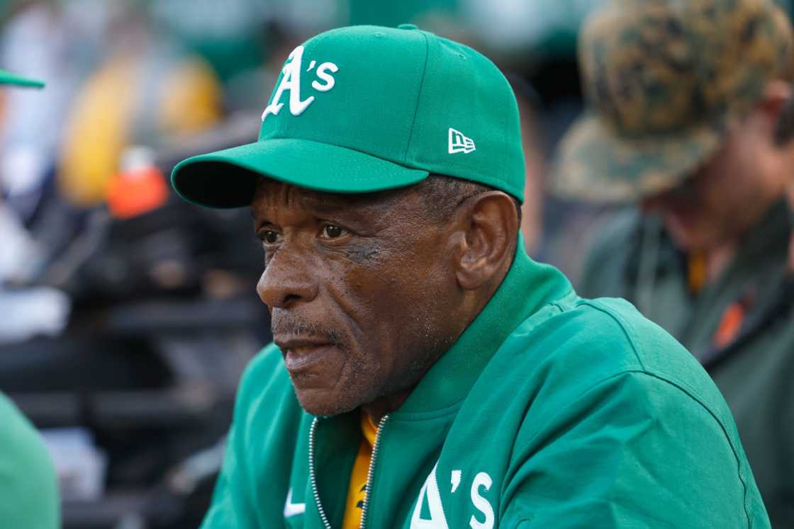 Rickey Henderson looks on in a green cap and jacket Rickey Henderson looks on in a green cap and jacket