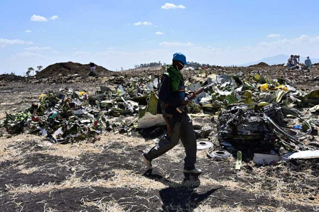 A man walks by a pile of twisted debris at the crash site of an Ethiopian Airways Boeing 737 MAX in March 2019