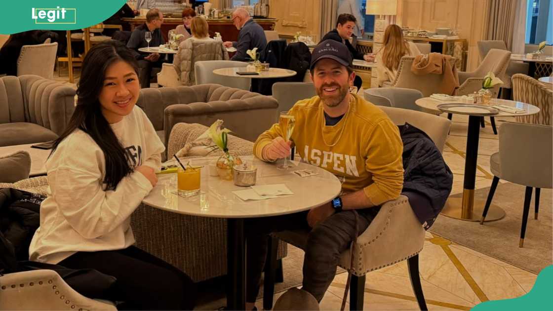 Matt and Khani sitting at a small round table as they pose while smiling Matt and Khani sitting at a small round table as they pose while smiling