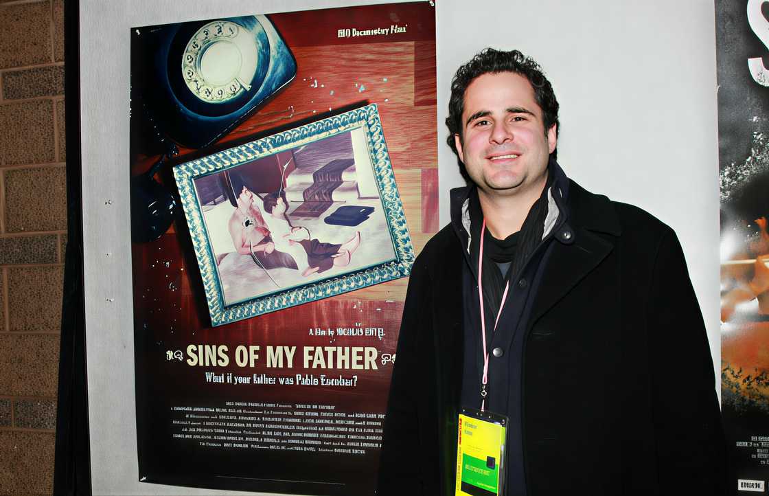 Director Nicolás Entel poses next to a poster of the documentary, Sins of My Father Director Nicolás Entel poses next to a poster of the documentary, Sins of My Father