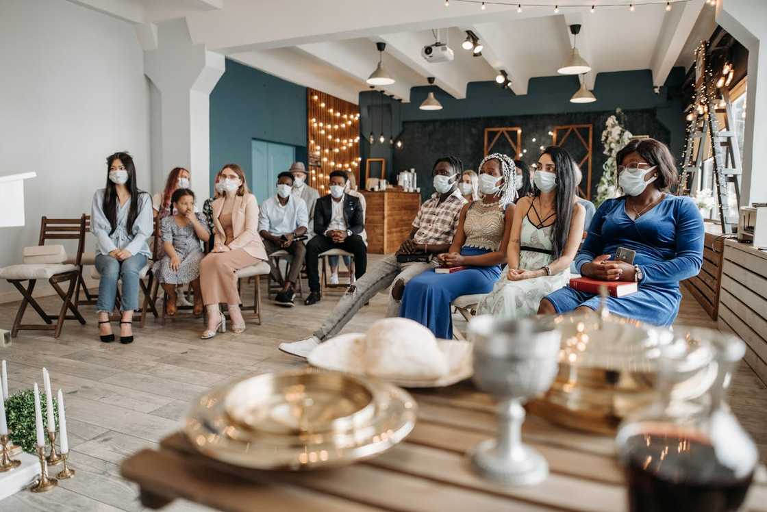 Church congregation seated indoors during a service with communion table. Church congregation seated indoors during a service with communion table.