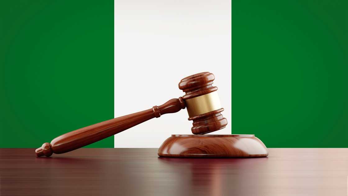 Wooden gavel in front of Nigerian flag.