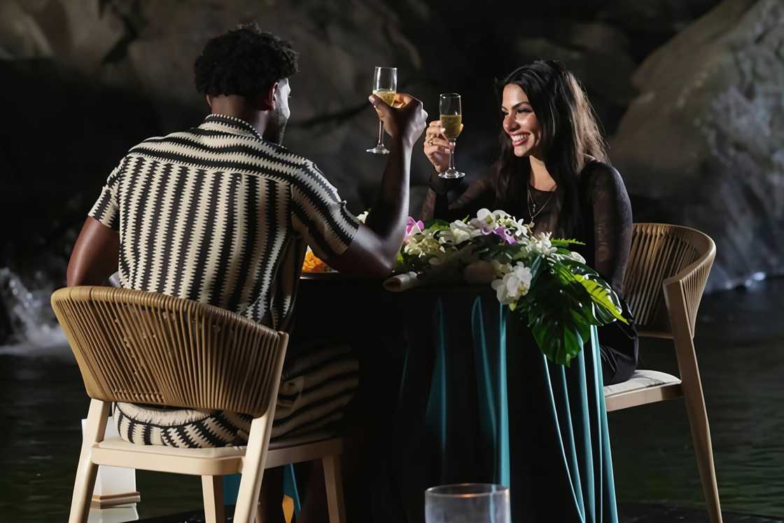 Chris Seeley and Huda Mustafa raise glasses during a dinner