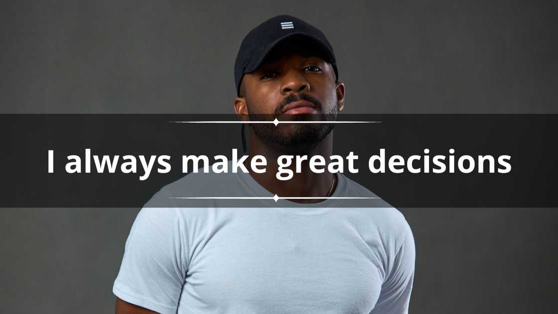 A man in a black cap and a plain white tee against a grey background
