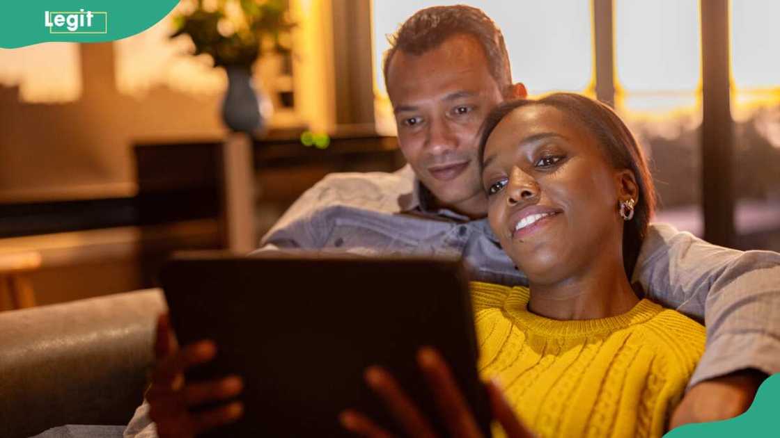 Couple watching a movie together on their sofa Couple watching a movie together on their sofa