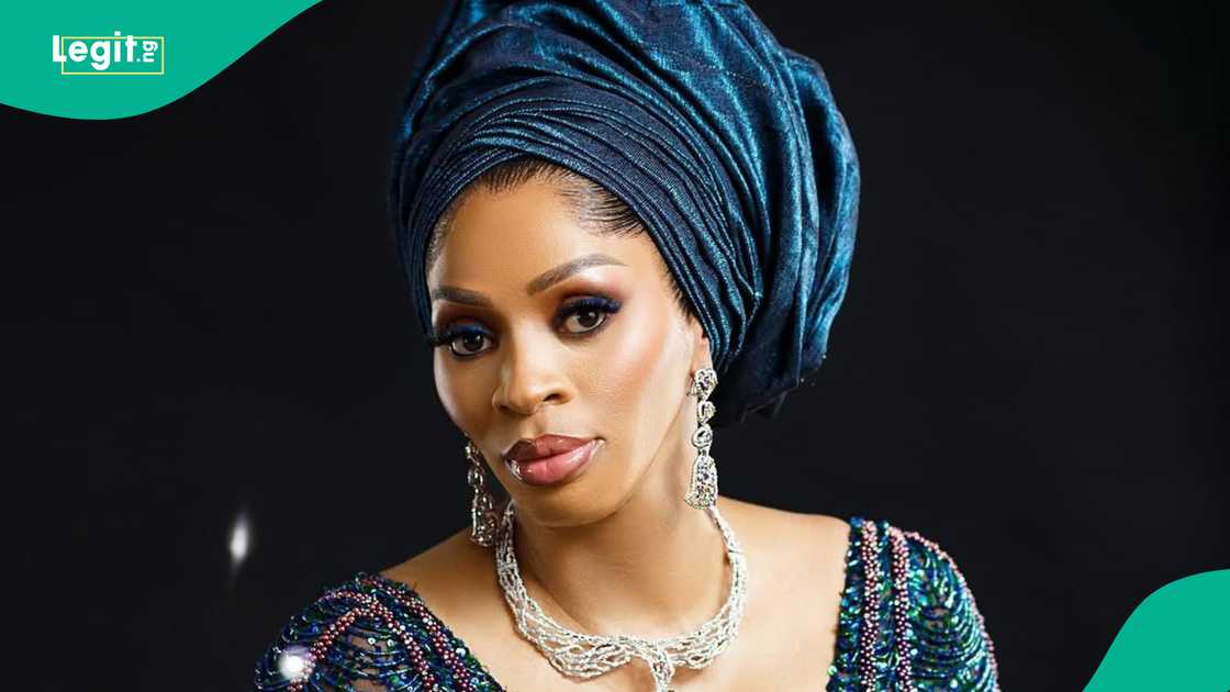 Businesswoman Shade Okoya kneels to greet KWAM 1 at Lagos event.