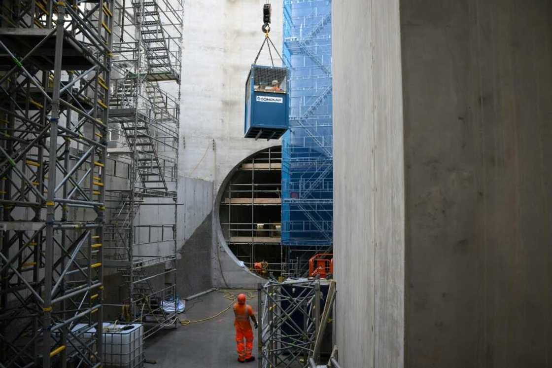 Construction workers are lowered 40 metres (130 feet) down a vertical shaft Construction workers are lowered 40 metres (130 feet) down a vertical shaft