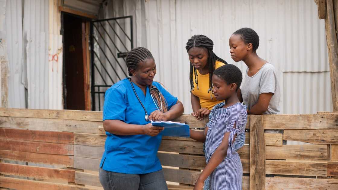 An African social health worker conducts a health education session with locals. An African social health worker conducts a health education session with locals.