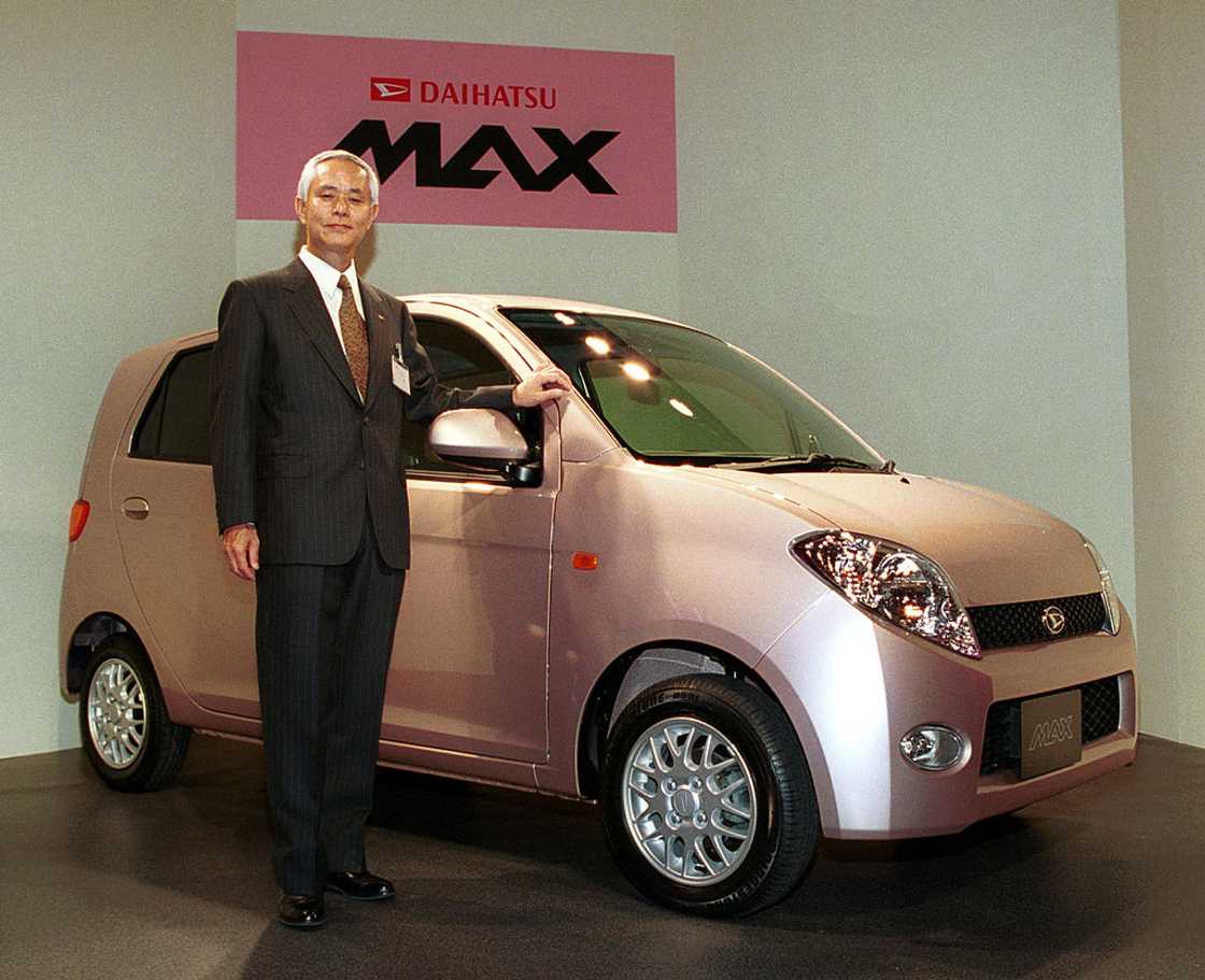 Japan's Daihatsu Motor President Takaya Yamada standing next to a Daihatsu MAX Japan's Daihatsu Motor President Takaya Yamada standing next to a Daihatsu MAX