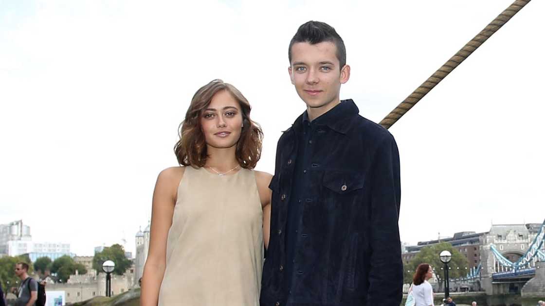 Ella Purnell poses with co-actor Asa Butterfield on a field during a photocall.