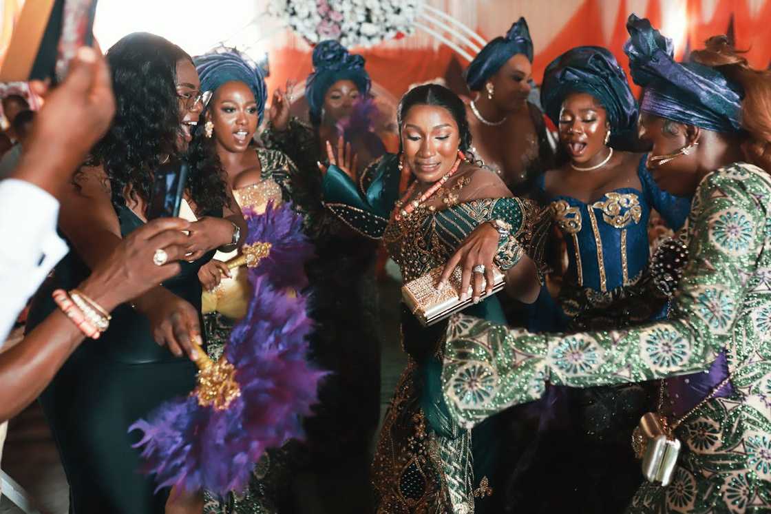 Women in coordinated traditional outfits dancing at a celebration. Women in coordinated traditional outfits dancing at a celebration.