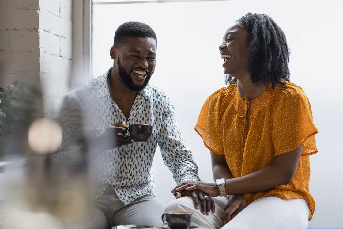 A young couple holding hands in cosy café.