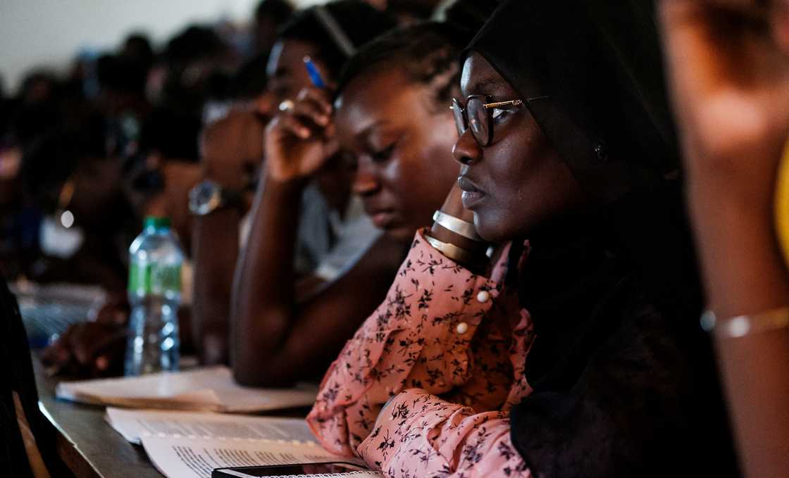 University students listen in during a lesson in a lecture theatre. University students listen in during a lesson in a lecture theatre.