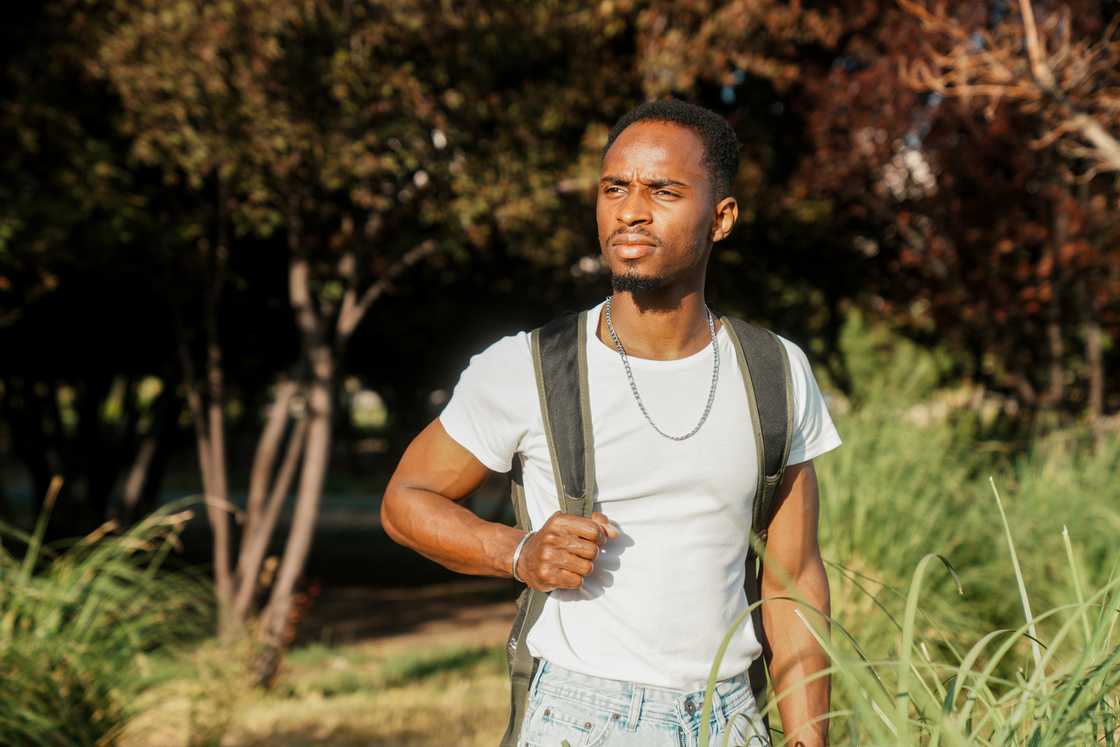 A student walking with a bag on his back A student walking with a bag on his back