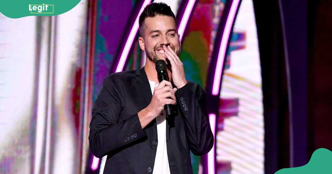 John Crist laughs on a stage at The Grand Ole Opry