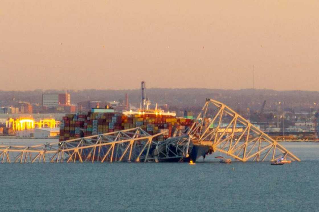 The steel frame of the Francis Scott Key Bridge sits on top of a container ship after it struck the bridge in Baltimore, Maryland, on March 26, 2024 The steel frame of the Francis Scott Key Bridge sits on top of a container ship after it struck the bridge in Baltimore, Maryland, on March 26, 2024