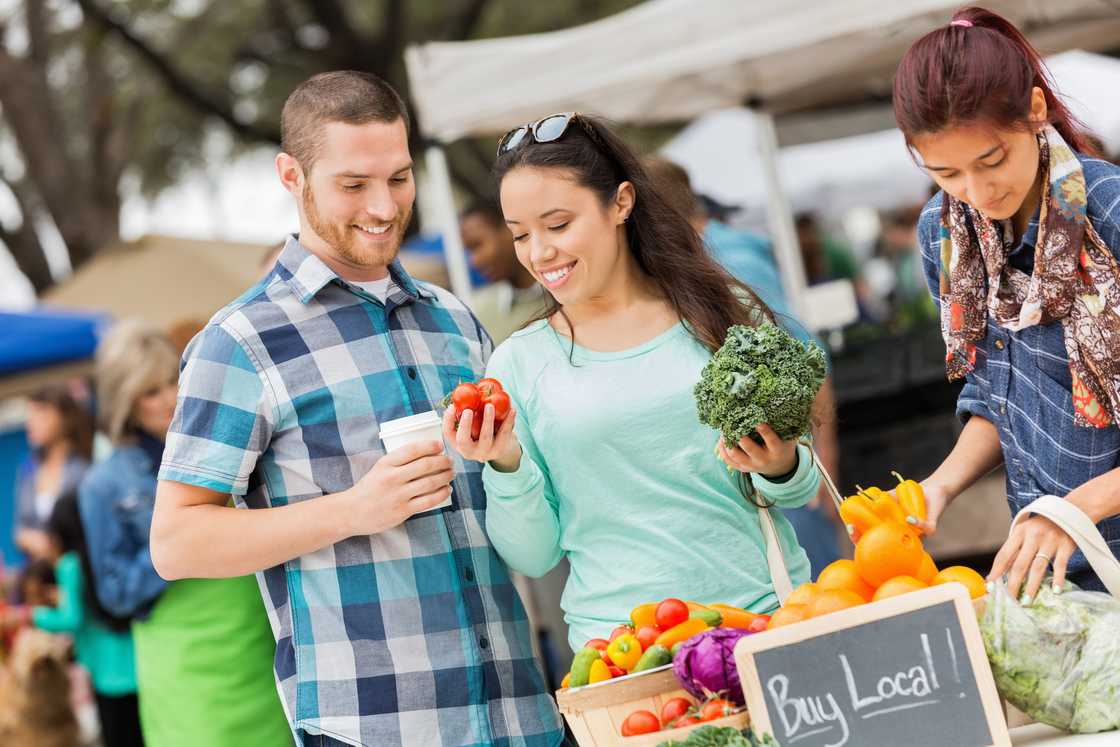 A couple shopping at a busy local farmers market. A couple shopping at a busy local farmers market.