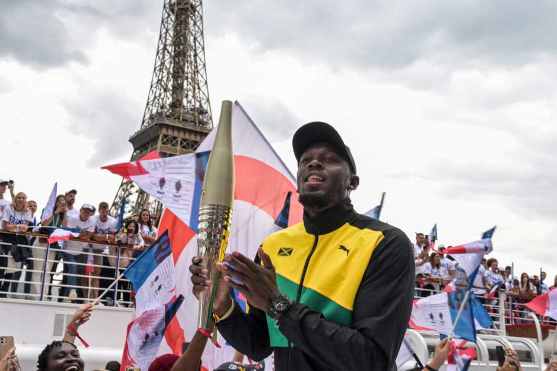 Usain Bolt holding the Olympic torch for Paris 2024