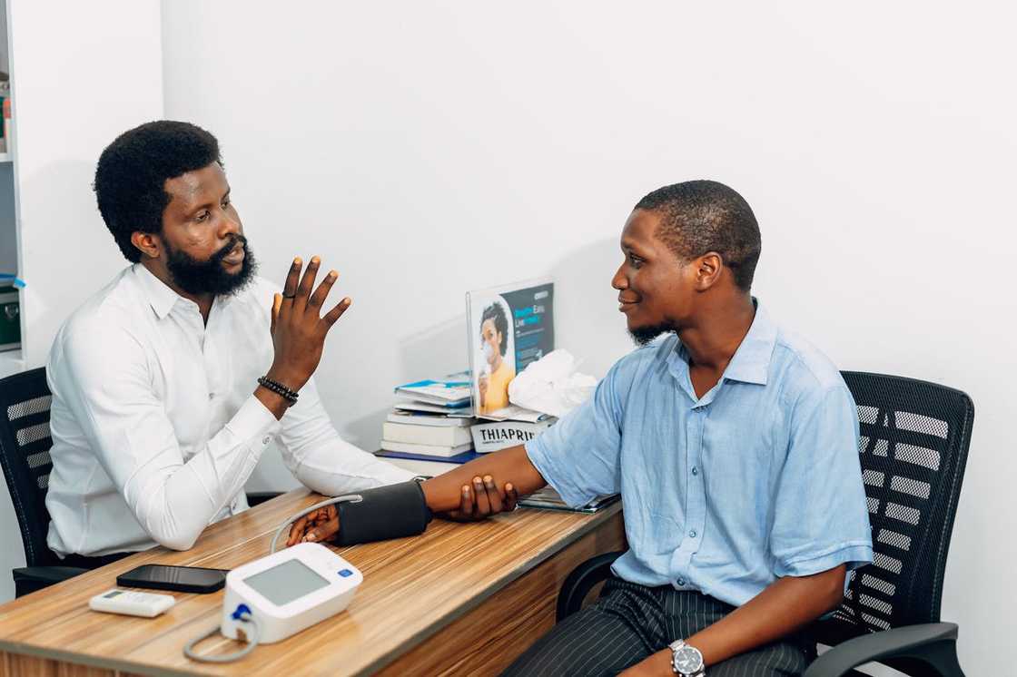Doctor checks a man’s blood pressure during a clinic visit.