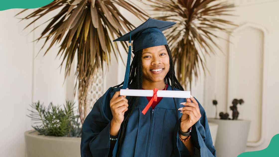 A lady smiles as she poses for a photo on her graduation A lady smiles as she poses for a photo on her graduation