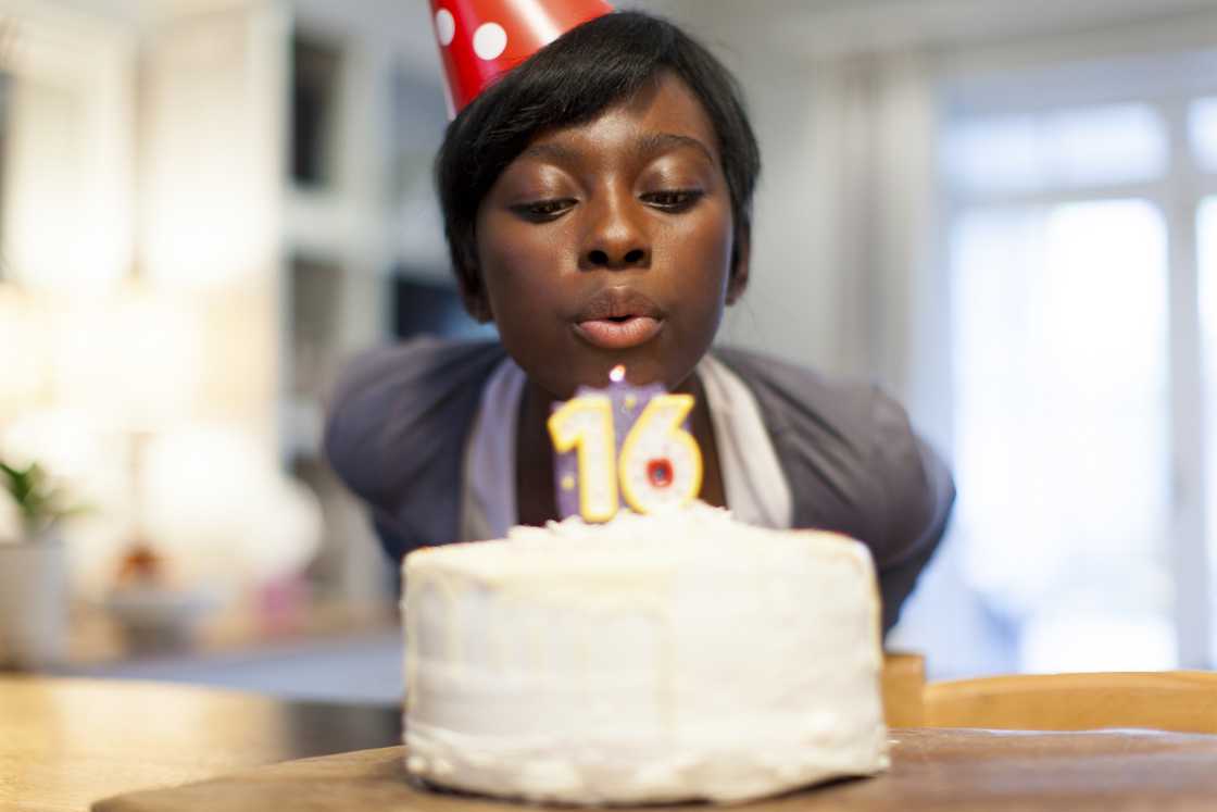 A female teenager gusting out the candle on her 16th birthday cake A female teenager gusting out the candle on her 16th birthday cake