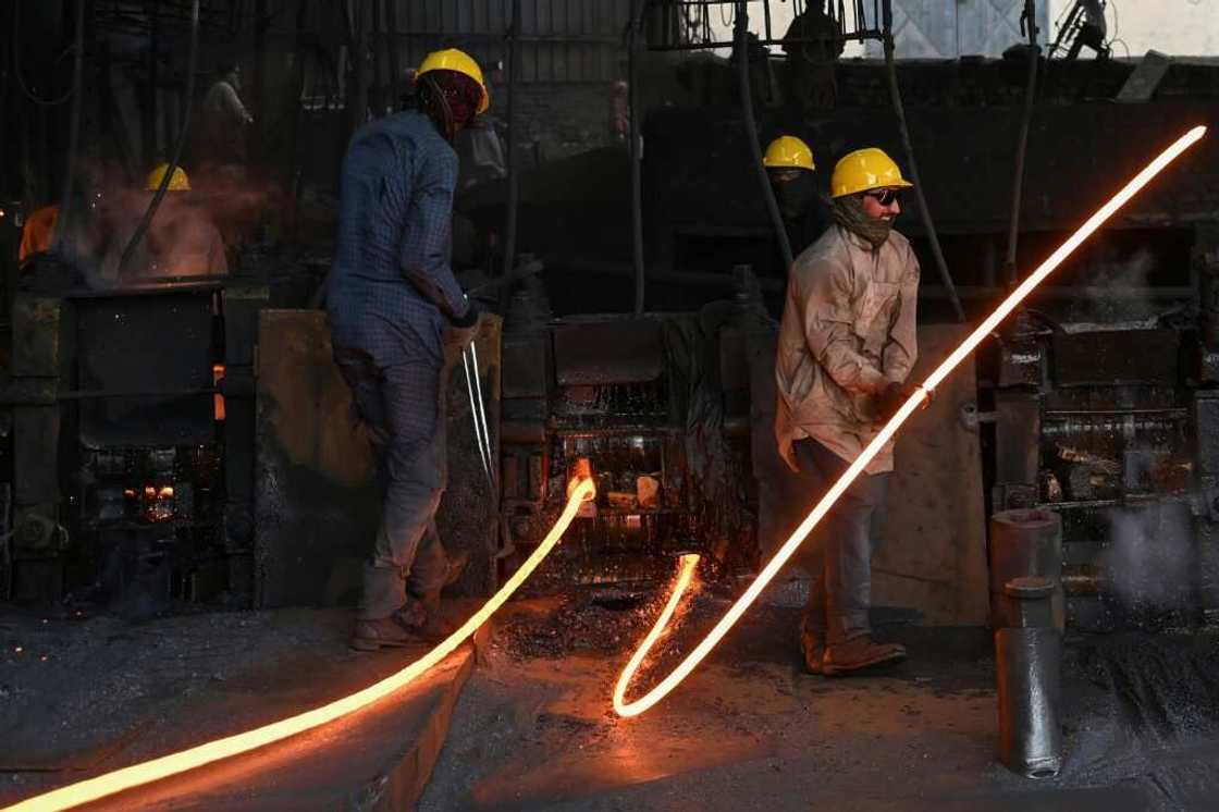 Labourers mould molten steel rods at a mill in Islamabad Labourers mould molten steel rods at a mill in Islamabad