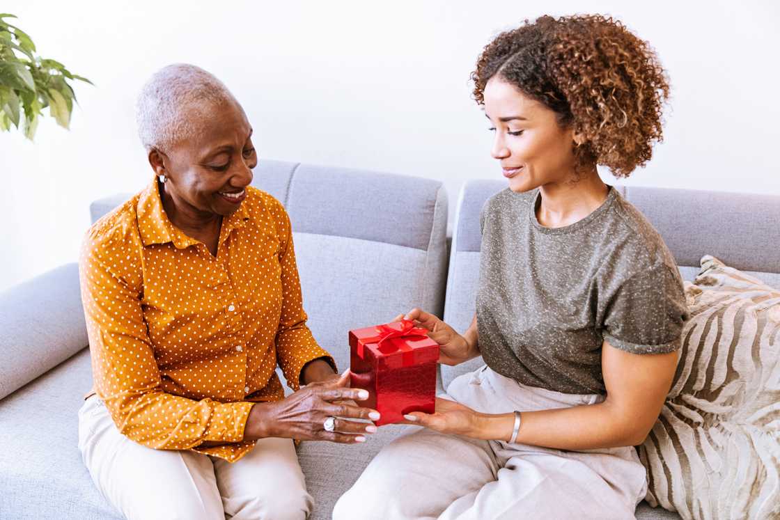 A gift exchange between two people on the couch. A gift exchange between two people on the couch.