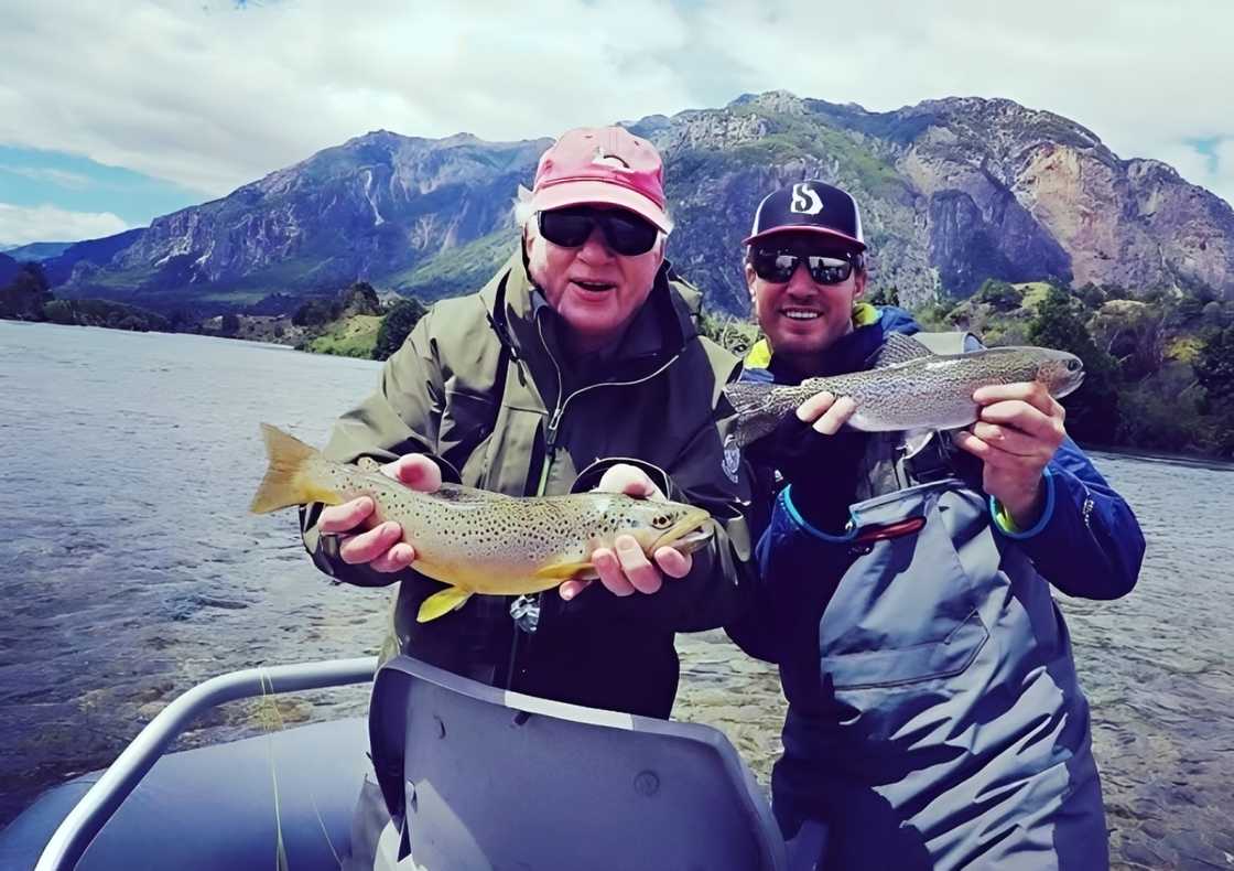 Shep Rose and William Shepard Rose Jr. pose holding fish in a lake