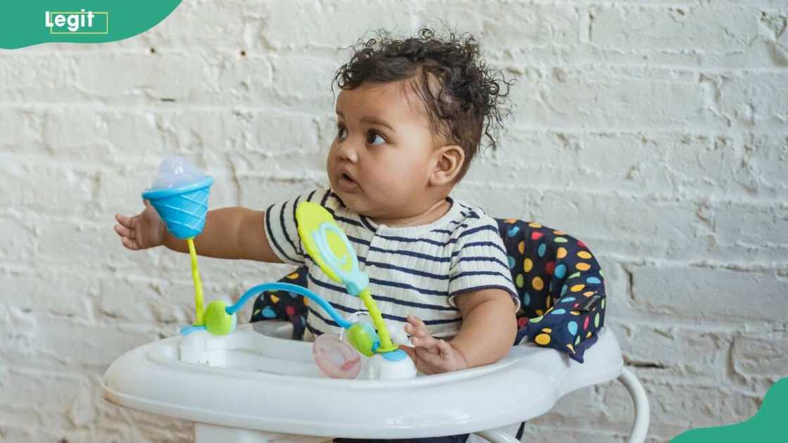 A baby playing in a walker