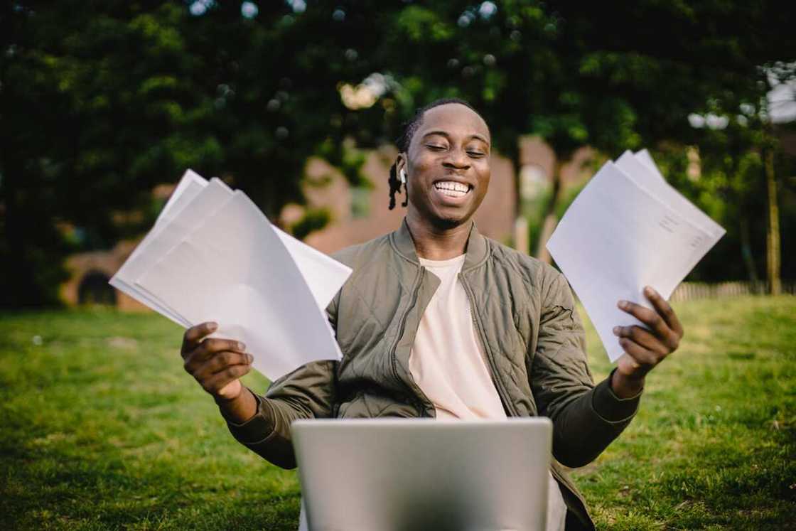 A happy student holding papers