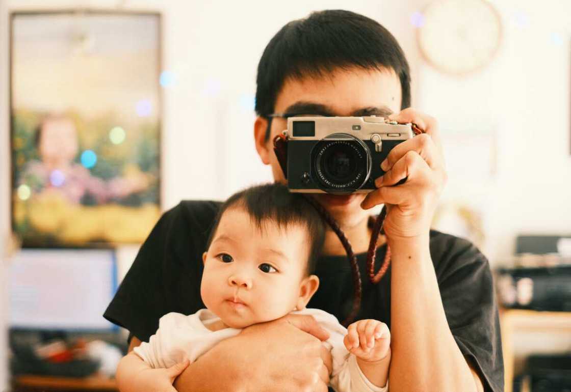 A parent taking a mirror selfie with her kid