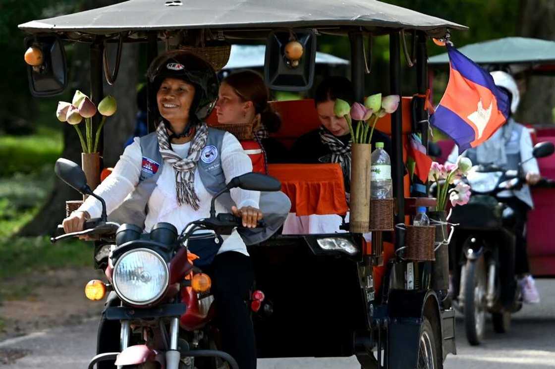 Tuk-tuk driver Kim Sokleang transporting  passengers near the Bayon temple at the Angkor complex in Siem Reap province Tuk-tuk driver Kim Sokleang transporting  passengers near the Bayon temple at the Angkor complex in Siem Reap province