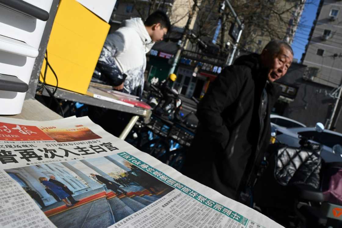 A newspaper featuring an image of Donald Trump arriving at the White House ahead of his inauguration as US President is seen at a news stand in Beijing on January 21