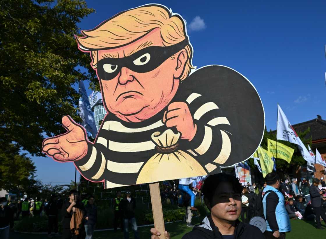 A South Korean protester holds a placard showing a caricature of Trump depicted as a thief during a rally against US President Trump's visit to attend the Asia-Pacific Economic Cooperation (APEC) Summit, in Gyeongju on October 29, 2025 A South Korean protester holds a placard showing a caricature of Trump depicted as a thief during a rally against US President Trump's visit to attend the Asia-Pacific Economic Cooperation (APEC) Summit, in Gyeongju on October 29, 2025