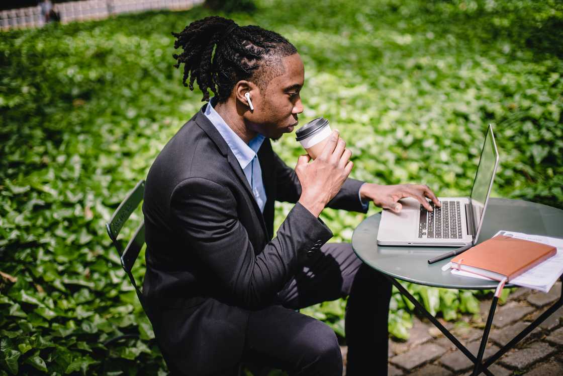 A young man working from a park