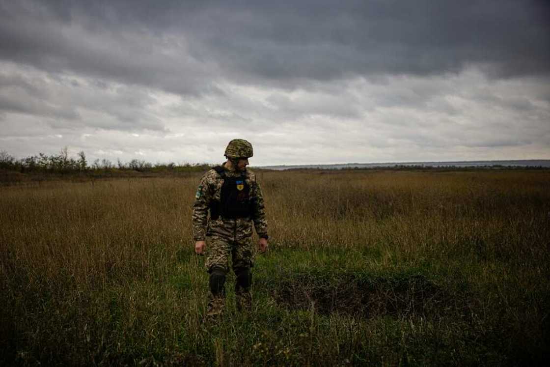 A Ukrainian serviceman stands next to a mortar crater in a field in the Donetsk region of eastern Ukraine A Ukrainian serviceman stands next to a mortar crater in a field in the Donetsk region of eastern Ukraine