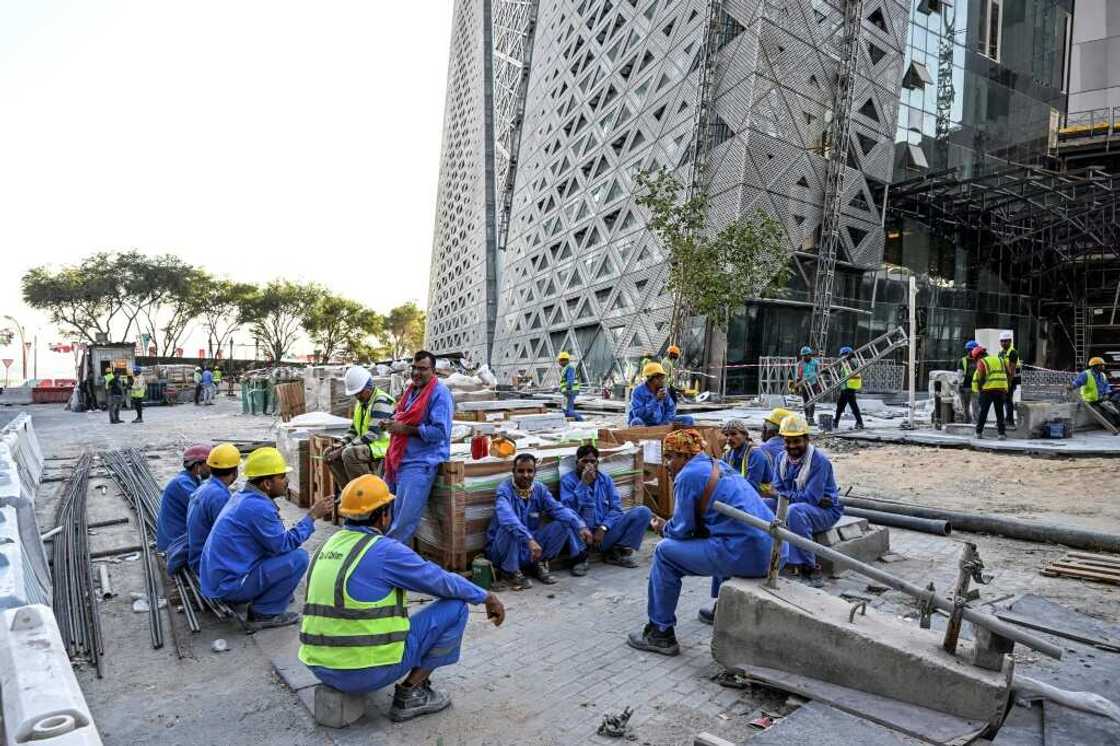 Migrant builders take a break while working at a construction site by the Corniche in Doha during the World Cup