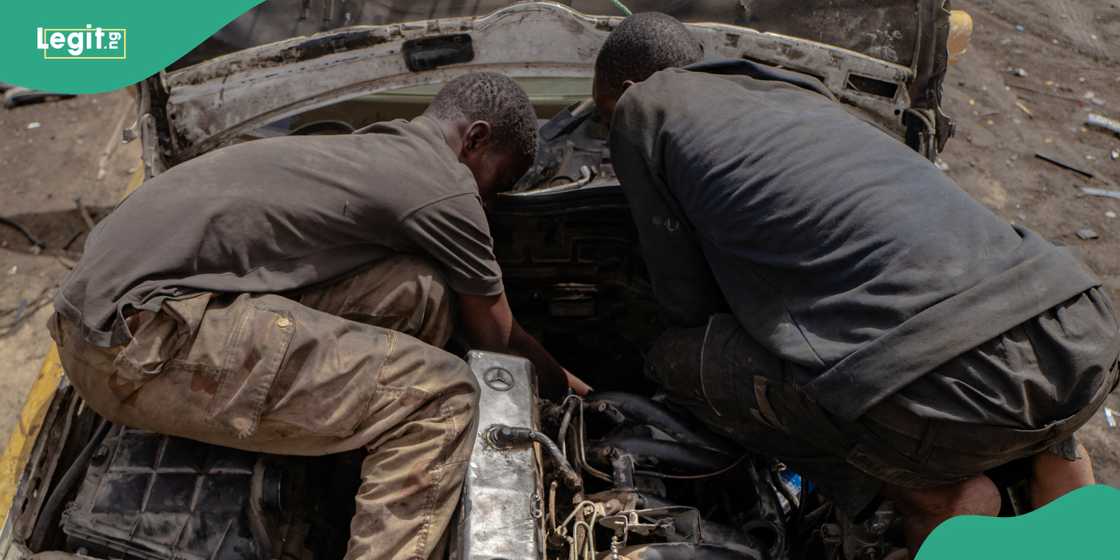 Mechanic works on car.