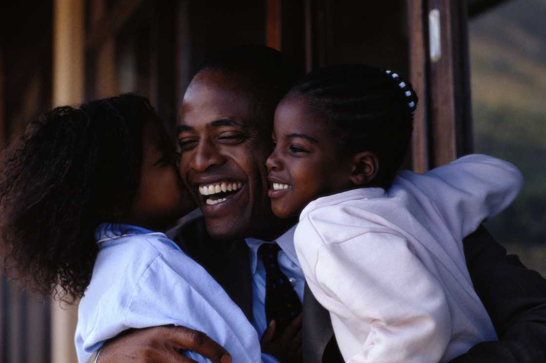 A father embracing his daughters A father embracing his daughters