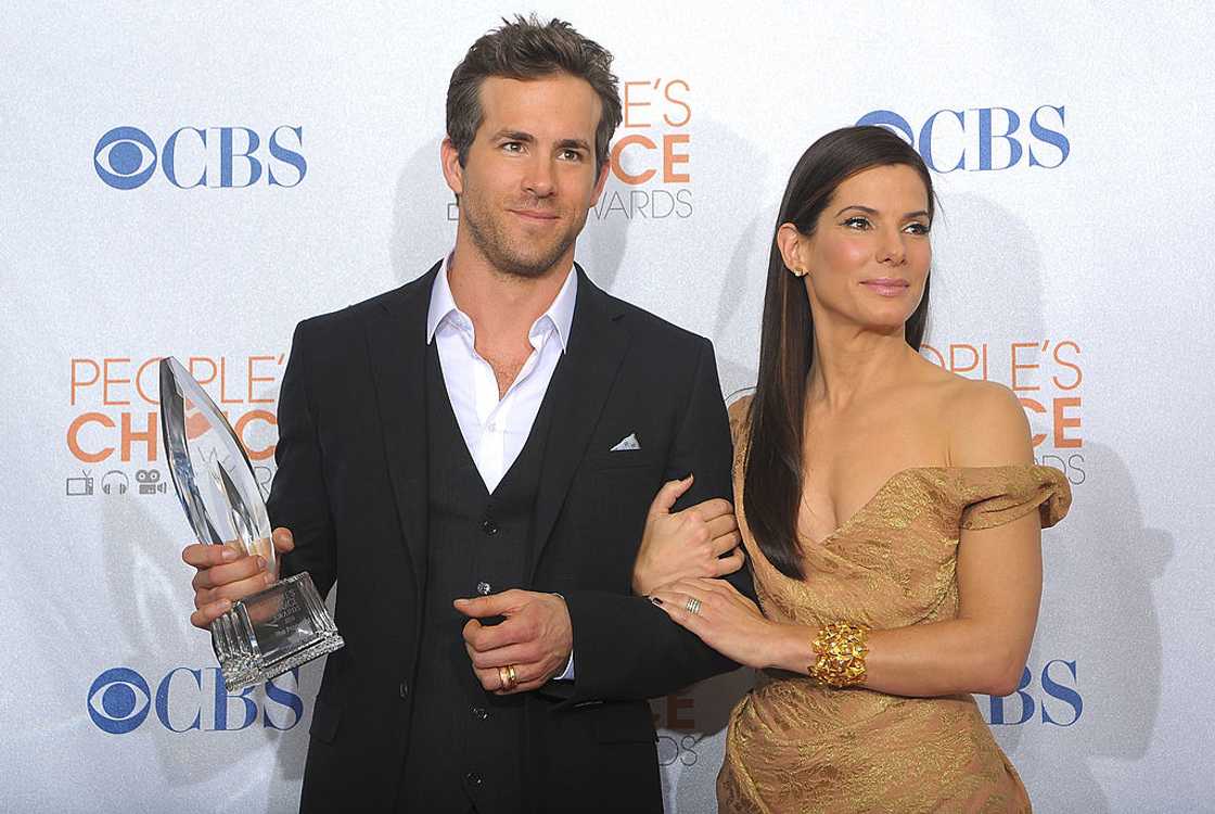 Ryan Reynolds (L) and Sandra Bullock pose for a photo during an award ceremony Ryan Reynolds (L) and Sandra Bullock pose for a photo during an award ceremony