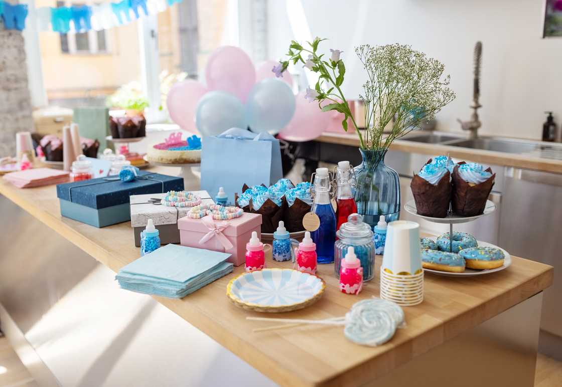 Baby shower party table with sweets, gifts, food and drinks. Baby shower party table with sweets, gifts, food and drinks.