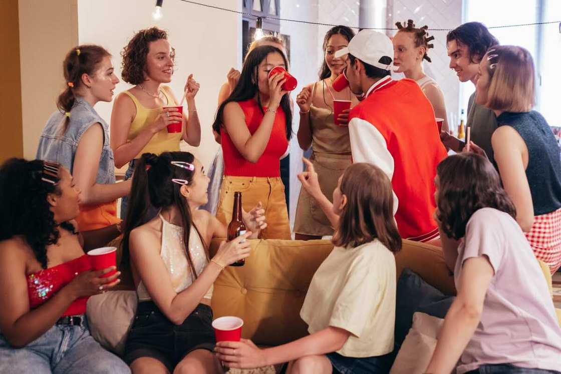 A group of young people at a party talking and drinking from red plastic cups A group of young people at a party talking and drinking from red plastic cups