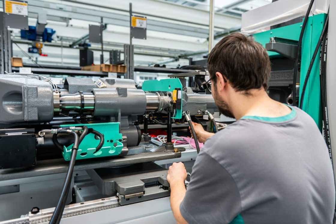 An employee works on a machine at the Arburg plant