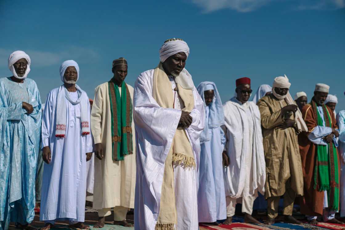 Man in traditional robes are praying